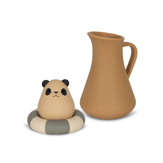 Jouets de Bain Pichet et Bouée Konges Slojd en silicone. Kit amusant avec pichet et panda sur bouée. Favorise l'imagination et la préhension. Fabriqué à 100% en silicone pour une expérience de bain sûre et ludique.